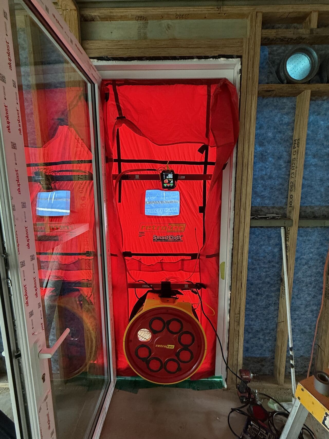 Retrotec blower door unit installed in an external doorway during a mid-construction airtightness test