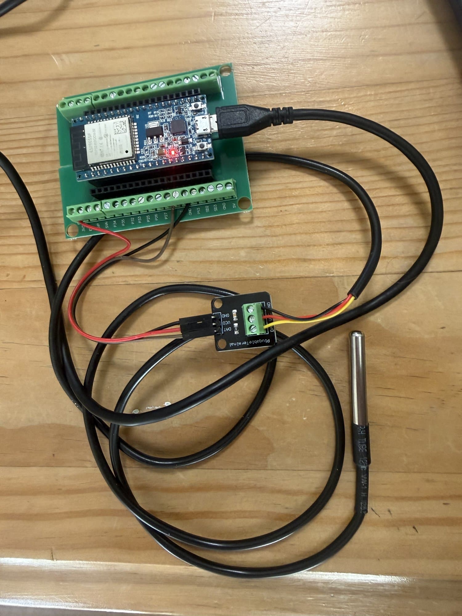 ESP32-based sensor node with a waterproof pipe temperature probe, built for the automatic shower boost feature